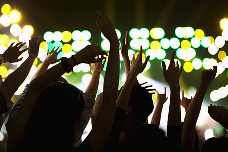 观众观看摇滚表演 双手在空中 后视 舞台灯人类乐队手势青年听力夜生活双臂摄影年轻人庆典图片