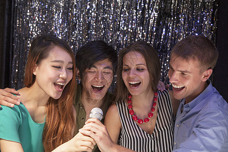 四个朋友在卡拉OK一起唱歌图片