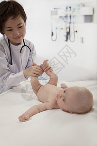 微笑的医生在医生办公室检查婴儿女婴摄影短发病人童年棕色头发医护人员儿科膀子图片