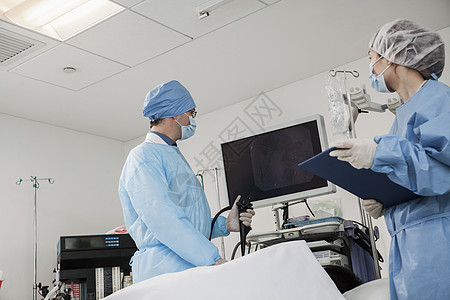 两名外科医生准备手术 病人躺下防护手术室保健手术衣医疗眼镜低角度检查倾斜年轻人图片