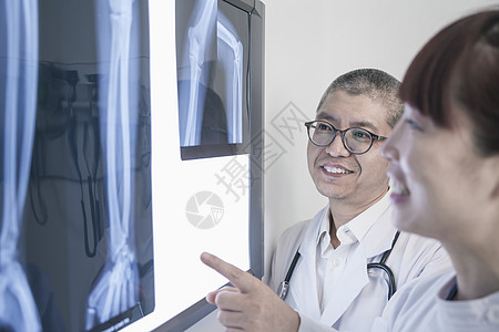 两个微笑的医生 看着尸骨X光片 指着图片