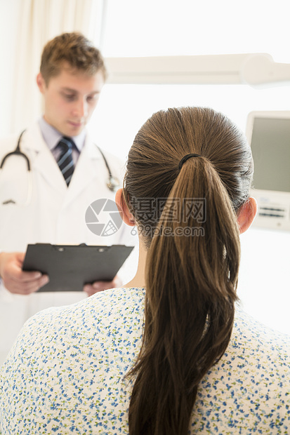 医生与一位病人讨论病历表 患者坐在医院的床上工作职业长发专业医护人员考试医疗摄影收腰马尾辫图片