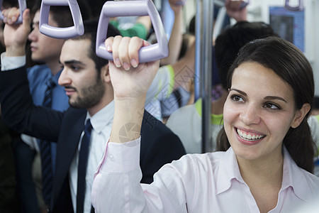 站在地铁站着的年轻女商务人士笑笑的肖像 向外望去图片