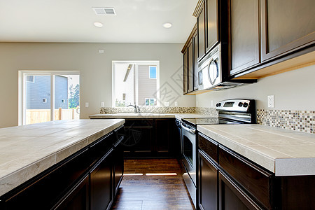 新家厨房内有深棕色柜子火炉凳子冰箱天花板建筑学财产房子公寓台面木头图片
