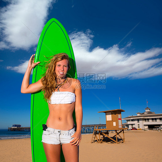 在海滩上持冲浪滑板的金黄色冲浪少女女孩快乐卷曲冲浪者海滨海岸女孩女士波浪冲浪板微笑图片