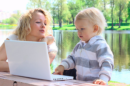 使用手提笔记本电脑的母婴母亲女士学习享受公园童年花园互联网草地女儿图片