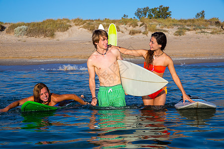 快乐的青少年冲浪者在海滩岸边聊天男生木板支撑运动朋友们海洋女性女士派对冲浪图片