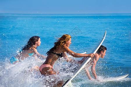 男童和女童青少年冲浪者在冲浪板上冲浪支撑假期跑步波浪木板男生女士女孩们女性朋友们图片