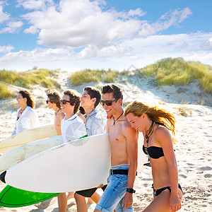 在海滩上行走的少年男女儿童群体女孩们派对天空热带冲浪板享受朋友们太阳镜团体波浪图片