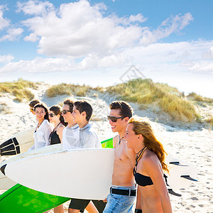 在海滩上行走的少年男女儿童群体青年波浪冲浪男孩们团体派对团队女孩们比基尼冲浪板图片
