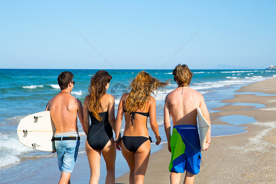 男孩和女孩在海滩上走后视线蓝色泡沫青少年天空比基尼波浪派对冲浪者支撑海洋图片