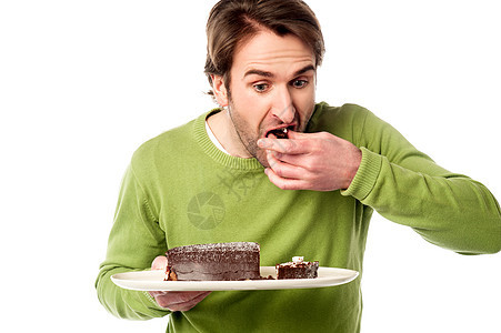 年轻人在吃巧克力蛋糕时匆忙图片