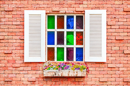 砖墙上多彩的窗户木头壁板塑料红色蓝色棕色建筑白色框架玻璃图片