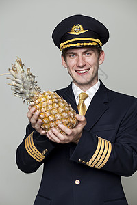 年轻男子以客机驾驶员的形式出现水果男人工作驾驶航空公司喷射肩章尖顶帽航班队长图片
