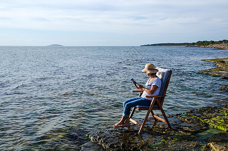 放松娱乐美丽座位闲暇帽子阳光椅子支撑场景乐趣海岸图片