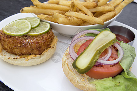 蟹饼汉堡和法式薯条馒头餐厅午餐螃蟹油炸桌子鳕鱼蛋糕面包洋葱图片