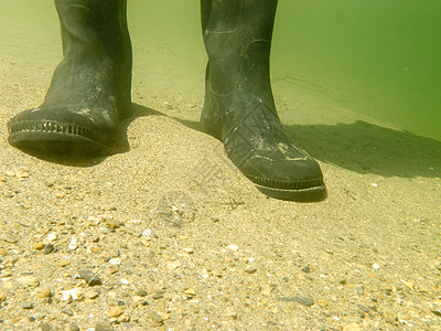 沙地下水下的橡胶靴或橡皮软糖鞋类阴影洪水靴子运动钓鱼卵石阳光涉水石头图片