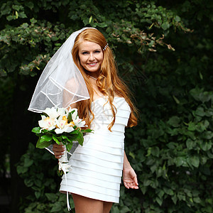 穿着婚纱的美丽红发新娘微笑婚姻礼服青年公园女孩女士花束花朵派对图片