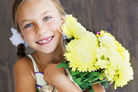 持鲜花儿童女学生喜悦女孩乡村童年快乐棕色工作室青年花朵图片
