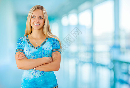年轻微笑的女青年窗户背景女性成人棕褐色双臂蓝色白色快乐喜悦图片