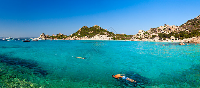 海里游泳撒丁岛湾的潜水员背景