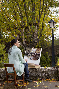 年轻女子在公园上画画帆布成人画家画笔活动艺术女性刷子调色板爱好图片