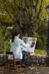 年轻女子在公园上画画艺术闲暇成人调色板享受艺术品画笔帆布女性刷子图片