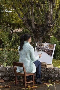 年轻女子在公园上画画活动爱好享受快乐画笔艺术成人女性调色板画家背景图片
