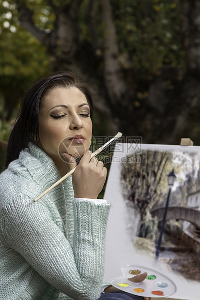 年轻女子在公园上画画爱好思维艺术家活动思考闲暇艺术品帆布调色板画笔图片