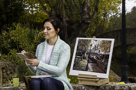 年轻女子在公园上画画艺术家活动画家艺术品调色板成人女性刷子闲暇日记图片