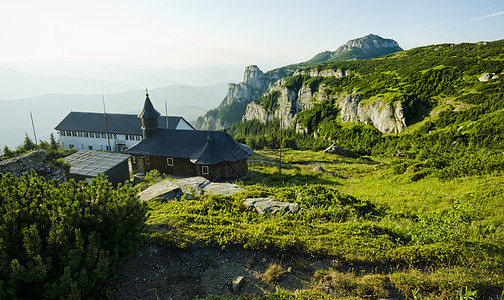 山上的教堂上帝旗帜场景建筑学绿色木头岩石森林宗教教会图片