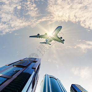 城市上空的飞机地点办公室商业建筑学天空摩天大楼蓝色旅行景观航空图片