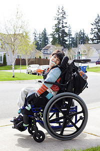 坐在轮椅上快乐的残疾小男孩孩子健康医疗微笑幼儿园男性乐趣机动性脑瘫男生图片