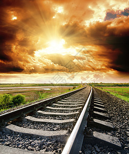 日落时铁路到阴云的天空图片