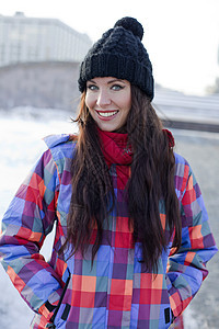 冬季城市背景中一位年轻女性的肖像街道雪花外套黑发幸福手套薄片季节衣服享受图片