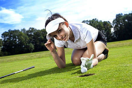 在草地上打高尔夫的漂亮女孩俱乐部男人爱好女孩遮阳棚闲暇游戏高尔夫球运动玩家图片