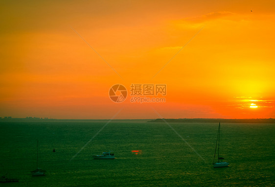 美丽的海日落太阳反射橙子天空游艇日出地平线热带航行海洋图片