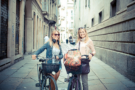 两个漂亮的金发美女 骑自行车购物城市金发女郎女士微笑女性朋友们幸福街道美丽友谊图片