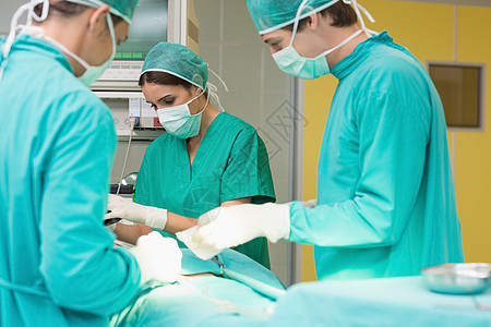 外科医生和他的团队在病人身上工作医疗闪电磨砂膏手术帽男性手术女性口罩手术室男人图片