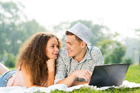 一对夫妇一起躺在公园里 带着笔记本电脑女士商业闲暇生活喜悦技术青年夫妻网络女性图片