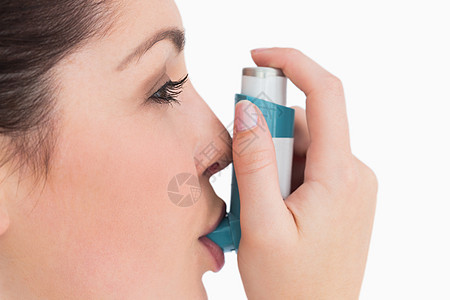 患有哮喘吸入器的妇女蓝色呼吸黑发女性爆头头发棕色疾病女士背景图片