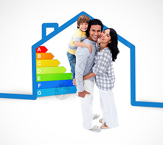 微笑的家庭站在一个蓝色房子插图和能源评级图表的蓝房子旁背景图片
