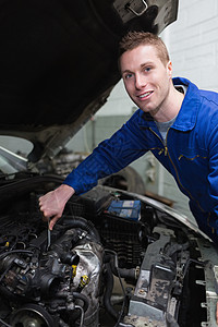 维修汽车发动机的年轻机械工图片