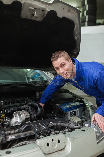 在汽车帽下工作的机械工工程师男人服务职业检查工作服修理车辆修复引擎图片