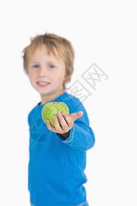 年轻男孩拿着绿苹果的肖像图片