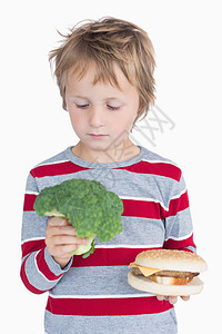 男孩拿着西椰菜和汉堡头发男性条纹蔬菜男生金发女郎童年浅色金发图片