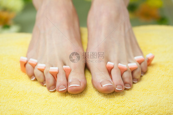 特写法国修剪的脚指甲毛巾指甲油分隔器修脚美甲脚趾治疗美容美容院图片