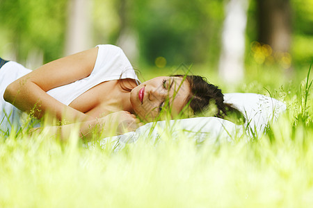 睡在草地上的女人枕头绿色睡眠白色场地女性公园自由女孩毯子图片