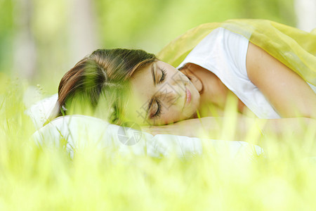 睡在草地上的女人绿色白色场地自由女孩毯子枕头睡眠公园女性图片
