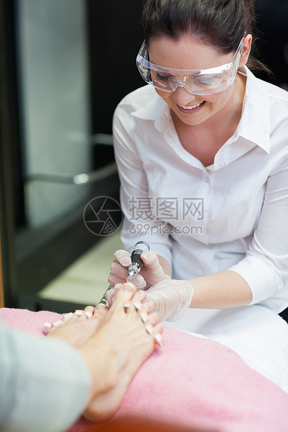 针甲技术技师脚踏脚卸下电棍美甲师皮肤科美容院眼镜女性顾客治疗组织修脚美容师图片